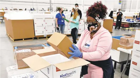  ?? TIMOTHY D. EASLEY/AP PHOTOS ?? An employee with McKesson Corp. packs a box of the Johnson & Johnson COVID-19 vaccine into a cooler for shipping from its facility Monday in Shepherdsv­ille, Kentucky.