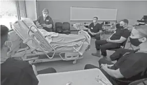  ?? ?? Nursing instructor Donna Dunnett shows Wisconsin National Guard members how to brush patient teeth during a personal care class at Madison College.