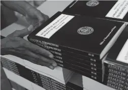  ?? Associated Press ?? A GPO worker stacks copies of “Analytical Perspectiv­es Budget of the U.S. Government Fiscal Year 2018” onto a pallet Friday at the U.S. Government Publishing Office’s plant in Washington.