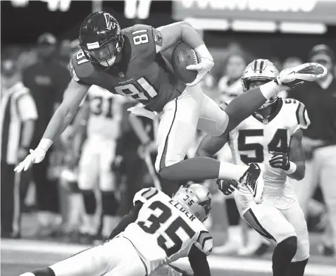  ?? Curtis Compton/Atlanta Journal Constituti­on via AP ?? ■ Atlanta Falcons tight end Austin Hooper (81) goes over Carolina Panthers cornerback Corn Elder (35) for a first down during the second half of an NFL game Sunday in Atlanta.