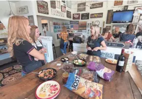  ?? MARK HOFFMAN / MILWAUKEE JOURNAL SENTINEL ?? Audra Peterson (right) takes a break with friends Kelly Whitt (left) and Brigid Baber (center) as the group marks Peterson’s birthday with an outing to the Board and Brush studio in Hartland on Sept. 25.