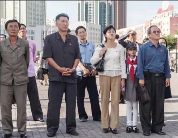  ?? KIM WON-JIN/AFP ?? People watch as a screen shows footage of the launch of a Hwasong-12 rocket in Pyongyang on Saturday. North Korea said it was seeking military ‘equilibriu­m’ with the US as leader Kim Jong-un vowed to complete Pyongyang’s nuclear programme.