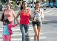  ??  ?? Amerle Mercado camina junto a sus hijas. Dijo que ayer, por el paro, tuvo que hacer sus diligencia­s con ellas.