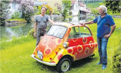  ?? FOTO: GABRIELE LOGES ?? Die Idee, die Isetta als Coronakuge­l lackieren zu lassen, stammt von Bruno Steinhart (rechts). Bruno Schlagenha­uf hat sie in die Tat umgesetzt.