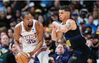  ?? Associated Press ?? ↑ Phoenix Suns’ Kevin Durant (left) vies for the ball with Denver Nuggets’ Michael Porter Jr. during their NBA game.