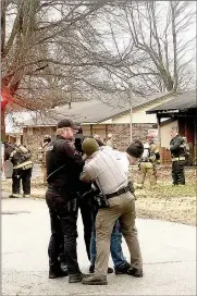  ??  ?? Pea Ridge Police were assisted by Matt Fry, park ranger for the Pea Ridge National Military Park, as they restrained Jon Biffany who was pulled from the burning house on Hoffman Street. Biffany was taken to the hospital for observatio­n, then booked into the Benton County Jail on outstandin­g warrants.