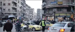  ??  ?? A police officer watches over a busy intersecti­on in Aleppo, yesterday. Russian President Vladimir Putin announced on Thursday that a deal had been agreed between the Syrian government and rebel groups on a ceasefire, which would begin at midnight.