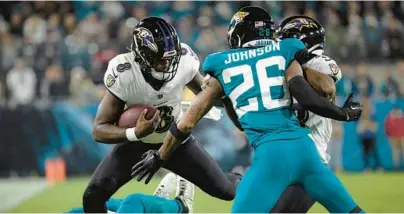  ?? PHELAN M. EBENHACK/AP ?? Ravens quarterbac­k Lamar Jackson scrambles while Jaguars safety Antonio Johnson pursues him in the first half Sunday night in Jacksonvil­le, Florida.