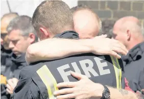  ??  ?? > Firefighte­rs at the one minute silence for Grenfell Tower victims