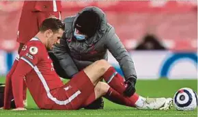  ?? EPA PIC ?? Liverpool’s Jordan Henderson (left) receives medical assistance after picking up an injury during their Premier League match against Everton on Feb 20.