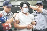  ?? — Gambar AFP ?? DITANGKAP: Suspek dikenal pasti sebagai Lu (tengah) diiringi polis di biro polis tempatan di Taipei semalam selepas dia disyaki menetak seorang pengawal polis tentera dengan pedang samurai di luar pejabat presiden.