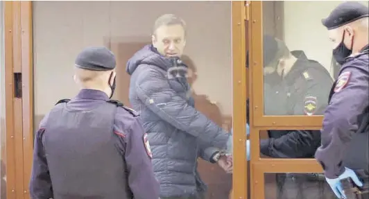  ?? Babushkins­ky Distric Court Press ?? Un policia li treu les manilles a Aleksei Navalni (al mig), abans de declarar en un tribunal rus, el 16 de febrer.