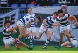  ?? Tony Ward ?? Michael Lowey of Blackrock is tackled by Belvedere’s Fergal O’Byrne