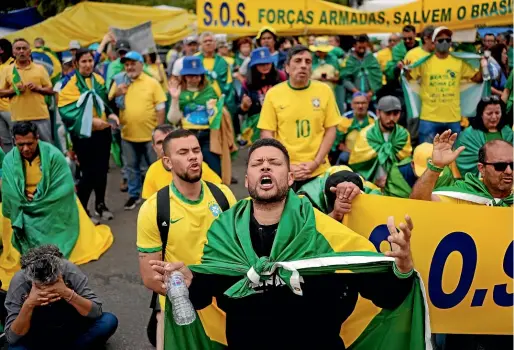  ?? AP ?? Supporters of Brazilian President Jair Bolsonaro pray during a protest outside a military base in Sao Paulo against his defeat in the country’s presidenti­al runoff.