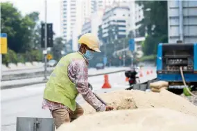  ??  ?? Like any other day: A constructi­on worker going about his usual routine during the haze.