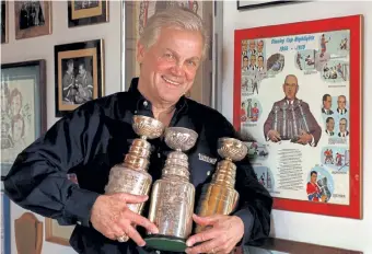  ?? Denver Post file ?? Former Montreal Canadien center and DU hockey coach Ralph Backstrom posed with three of the commemorat­ive Stanley Cup trophies he collected during his career.