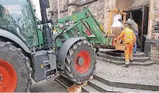  ??  ?? Mit einem Trecker ließ Landwirt Hanno Paas die Palette mit der 333 Kilogramm schweren Glocke über die Treppen von St. Peter und Paul wuchten.