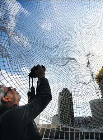  ?? LEAH HENNEL ?? Naved Altaf, from Ontario, photograph­s the Wonderland sculpture outside the Bow building as he explores the city on Sunday. In a report to city council, Tourism Calgary says the city welcomed 800,000 fewer tourists last year, dropping the number of...