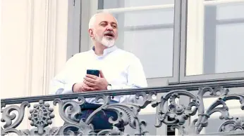  ?? (AP FOTO) ?? BREAK TIME. Iranian Foreign Minister Mohammad Javad Zarif talks to journalist­s from a balcony of the Palais Coburg where closed-door nuclear talks with Iran continue in Vienna, Austria.