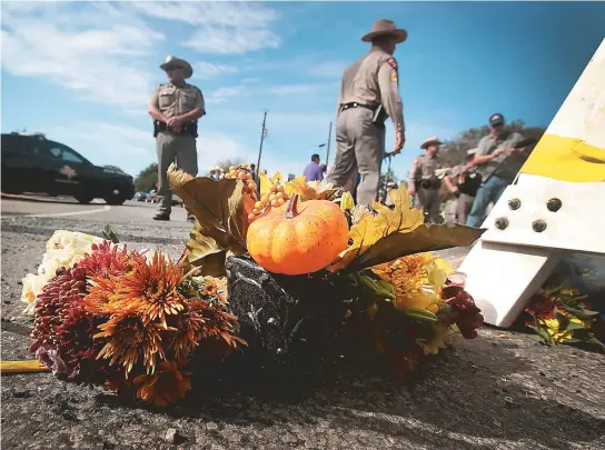  ??  ?? Moradores de Sutherland Springs deixaram flores para as vítimas junto à barricada policial nos arredores da igreja onde ocorreu o tiroteio