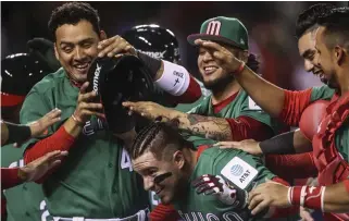  ??  ?? Mexico’s Esteban Quiroz celebrates with his teammates after hitting a home run against Venezuela during a World Baseball Classic game in Guadalajar­a, Mexico, Sunday. (AP)