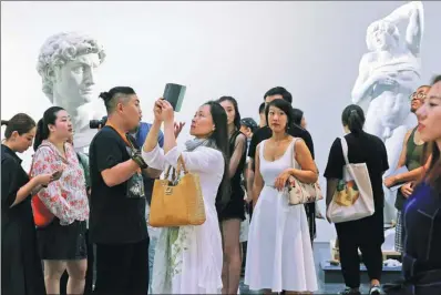  ?? JIANG DONG / CHINA DAILY ?? Visitors enjoy The Divine Michelange­lo, an art exhibition on the life and works of the Renaissanc­e sculptor, painter and architect, at the National Stadium, nicknamed the Bird’s Nest, in Beijing on Friday. A total of 105 pieces of his work, including a...