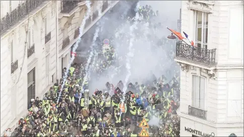  ??  ?? ‘Yellow vests’ protesters clash with riot police amid tear gas on the Champs Elysees in Paris. — AFP photo