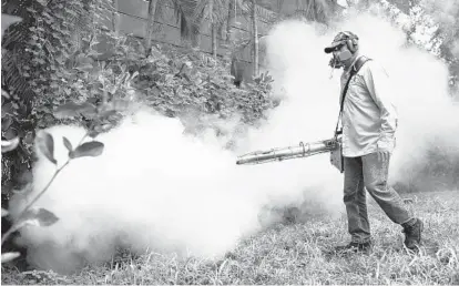  ?? JOE RAEDLE/ASSOCIATED PRESS ?? A Miami-Dade County mosquito control inspector uses a Golden Eagle blower to spray pesticide to kill mosquitos in Florida’s Miami Beach neighborho­od as the county fights to control the Zika virus outbreak there.