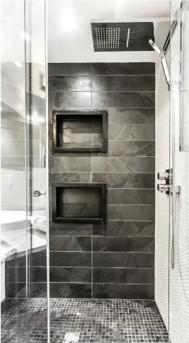  ??  ?? Dans les petites pièces, il vaut mieux uniformise­r les matériaux afin d'éviter de surcharger le décor. Ici, on a opté pour des carreaux d'ardoise naturelle en trois formats dans la douche et au sol. La mosaïque blanche, elle, crée un heureux contraste. Deux niches pratiques viennent en renfort pour combler les besoins en rangement.