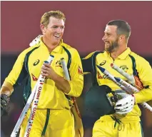  ?? – AFP ?? EMPHATIC WIN: Australia’s George Bailey, left, and Matthew Wade leave the field with the stumps after leading their team to seriesclin­ching victory in the fourth ODI match against Sri Lanka in Dambulla on Wednesday.