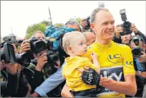  ?? AP PHOTO ?? Tour de France winner Britain’s Chris Froome, wearing the overall leader’s yellow jersey, holds his son Kellan after the twenty-first and last stage of the Tour de France cycling race over 103 kilometers with start in Montgeron and finish in Paris,...