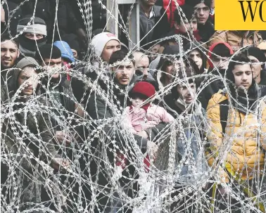  ?? SAKIS MITROLIDIS/AFP VIA GETTY IMAGES ?? Migrants in Turkey gather near Kastanies, a Greek border checkpoint, on Monday. Turkey has threatened to release a new wave of refugees toward Europe after western allies were cool to its calls for assistance.