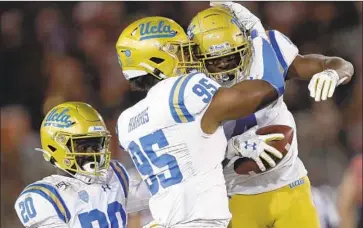  ?? Ben Margot Associated Press ?? JASON HARRIS, center, and Stephan Blaylock jump for joy after recovering a fumble against Stanford.