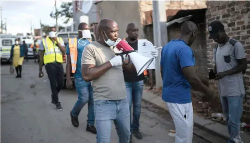  ?? | JEROME DELAY AP ?? WITH THE help of police, community activists patrol densely populated Alexandra township, Johannesbu­rg, on Monday, telling people to return to their homes. More than half of Africa’s 54 countries have imposed lock-downs, curfews, travel bans or other restrictio­ns to try to contain the spread of Covid-19.