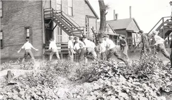  ?? HONS ?? In this 1919 photo provided by the Chicago History Museum, a victim is stoned and bludgeoned under a corner of a house during the race riots in Chicago. Hundreds of African Americans died at the hands of white mobs during “Red Summer,” as the summer of 1919 came to be known.