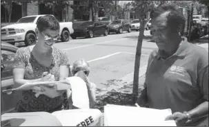  ?? The Associated Press ?? BALLOT PROPOSALS: Rachelle Tracy signs a petition on Thursday in downtown Little Rock from canvasser Cynthia Ford in favor of putting a minimum wage hike proposal on the November ballot. Friday is the deadline for initiative campaigns to submit signatures to qualify for the ballot. Ford circulated petitions for the wage hike proposal along with proposals to impose strict term limits and to legalize casinos.