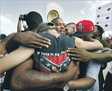  ?? Barbara Davidson Los Angeles Times ?? MEMBERS of All Lives Matter and Black Lives Matter come together for a group hug during a Dallas protest. Critics, including former New York Mayor Rudolph W. Giuliani, have called Black Lives Matter a racist group.