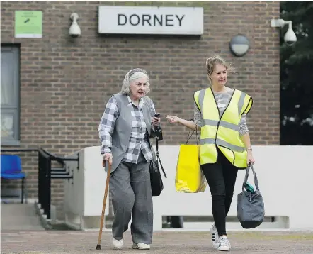  ?? — THE ASSOCIATED PRESS ?? A woman is helped from Dorney Tower in the borough of Camden on Sunday. The apartments were evacuated after inspectors concluded the building is unsafe because of external cladding similar to that blamed for the fire that engulfed Grenfell Tower on...