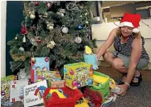  ?? MARTIN DE RUYTER/NELSON MAIL ?? Nelson regional editor Victoria Guild with some of the gifts that have been placed under The Nelson Mail Christmas Tree.
