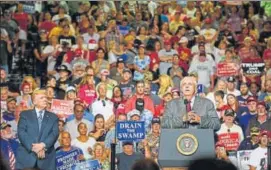  ?? AFP ?? Donald Trump listens as West Virginia governor Jim Justice announces his defection from the Democratic Party to the Republican Party at a rally in Huntington, West Virginia on Thursday.