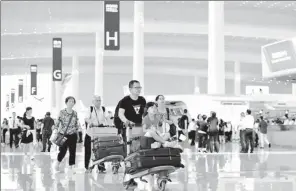 ?? XINHUA ?? Passengers walk through Terminal 2 of Guangzhou Baiyun Internatio­nal Airport.