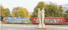 ?? FOTO: JAN WOITAS/DPA ?? Die Skulptur „Würde, Schönheit und Stolz des Menschen im Sozialismu­s“aus dem Jahr 1974 steht vor einer alten Tatra-Bahn, die heute als Begegnungs­zentrum genutzt wird.