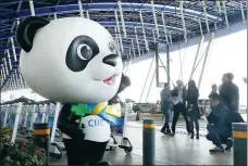  ?? CHEN FEI / XINHUA ?? Jinbao, the expo mascot, greets people at Pudong Internatio­nal Airport in