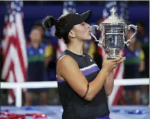  ?? CHARLES KRUPA — THE ASSOCIATED PRESS ?? Bianca Andreescu, of Canada, kisses the championsh­ip trophy after defeating Serena Williams, of the United States, during the women’s singles final of the U.S. Open tennis championsh­ips Saturday in New York.