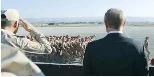  ?? (Reuters) ?? RUSSIAN PRESIDENT Vladimir Putin and Defense Minister Sergei Shoigu watch servicemen pass by yesterday as they visit the Hmeymim air base in Latakia Province in Syria.