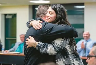  ?? PITTSBURGH POST-GAZETTE ?? Trafford Middle School special education teacher Alexis Simon, right, hugs co-teacher Michael Cleland during a school board meeting Feb. 6 in southweste­rn Pennsylvan­ia. Cleland, among others, was key in saving Simon’s life.