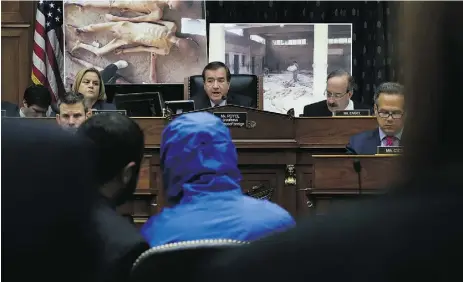  ?? Alex Wong / Gett
y Imag
es ?? A Syrian army defector code-named Caesar, in a blue hooded jacket, appears on Capitol Hill last year.