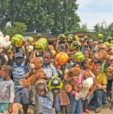  ??  ?? ABOVE: Children in Kliptown, Soweto, with the toys given to them by Children at Play.