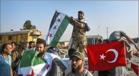  ?? Cavit Ozgul/Associated Press ?? Turkish-backed Syrian opposition fighters celebrate Sunday in Akcakale, Turkey, after entering over the border from Tal Abyad, Syria. State-run Anadolu news agency reported Tal Abyad had fallen to a Turkish military offensive on Sunday.