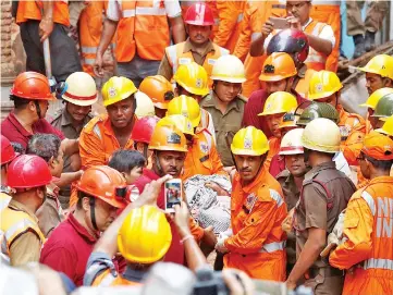  ??  ?? Rescue workers carry the body of a victim. — Reuters photo